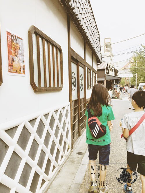 kids 2 and 3 walking besides a very Japanese style wall in Asakusa, Japan. One of the more traditional neighborhoods in Tokyo!