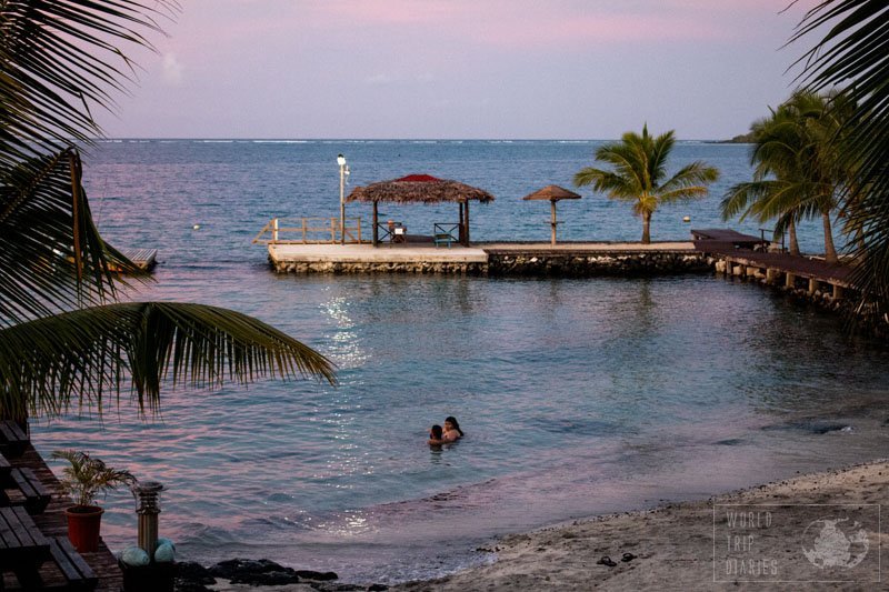 The pink and blue sunset over a beach in Samoa. Samoa is an incredible family travel destination. There's a little for every kind of traveler. Find out more!