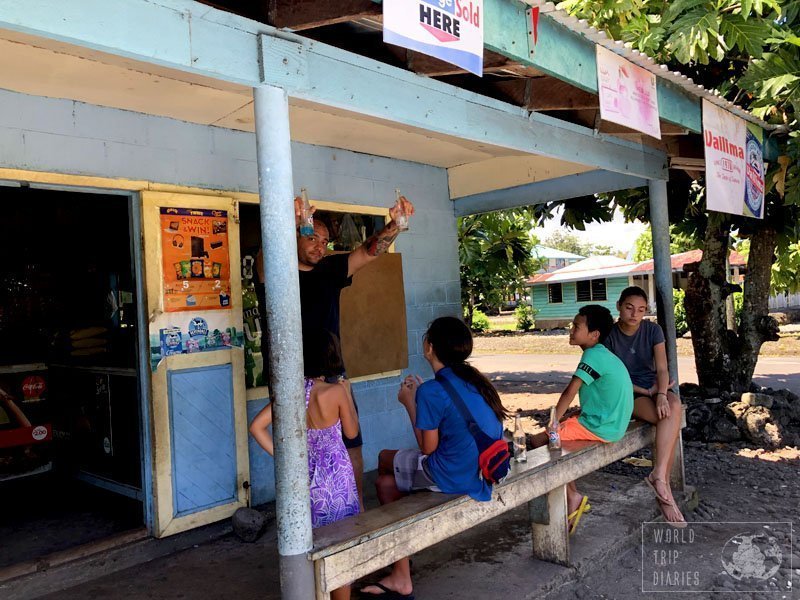 Dad and the kids resting in front of a store in Savai'i. We stopped to grab something to drink. The stores are almost always simple but they have a bit of everything. Click for more!